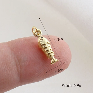 Detailed macro view of a 1.7cm golden fish charm with intricate scale textures