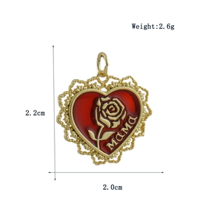 Macro view of a gold heart pendant with red enamel, MAMA text, and rose detail