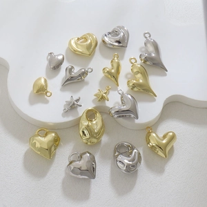 Polished heart and star metal charms for DIY jewelry making on a white display plate