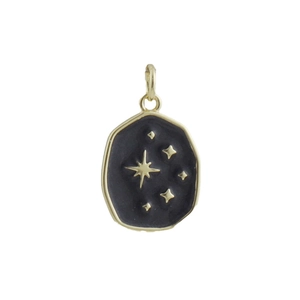 Close-up of a vintage gold-plated star pendant with black enamel and polar star detail