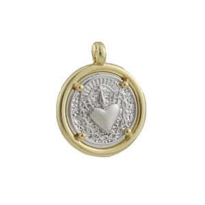 Macro detail of a vintage sacred heart charm with gold rim and silver relief