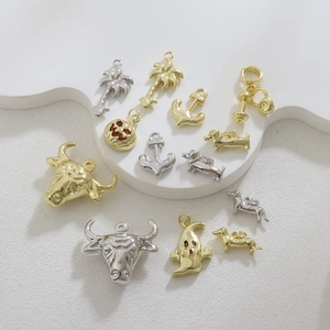 Macro-opname van diverse 18k goud en zilver vergulde bedels op witte stenen basis