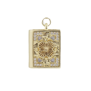 Macro view of gold-plated book pendant with clover pattern and sparkling zircon stones