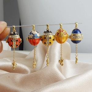 Makroaufnahme von Emaille-Eianhängern im Fabergé-Stil mit Zirkonia und kleinen Engelsfiguren