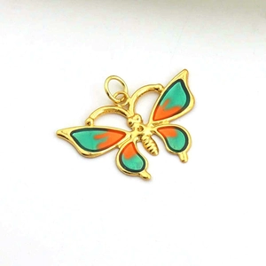 Detail of a butterfly pendant with orange and green enamel inlay and gold alloy edges