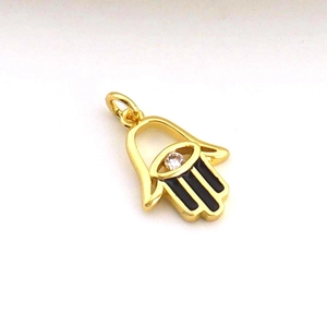 Detailed view of a golden Hamsa hand pendant with a small diamond and black enamel finish