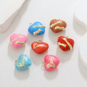 Dettaglio macro di ciondoli a cuore in smalto multicolore con placcatura in oro 18 carati