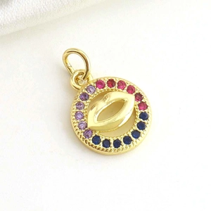 Macro detail of 18k gold plated round pendant with lip design and colorful crystals