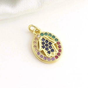 Macro view of 18k gold plated Hamsa hand pendant with colorful zircon stones inlay