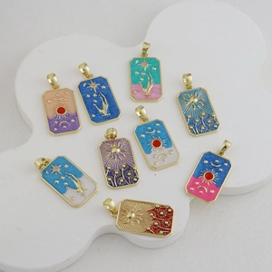 Detail of tarot card pendants with sun and moon enamel patterns on a wavy white stand