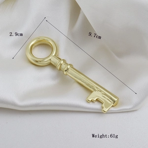 Gepolijste gouden vintage sleutelhanger, 9,7 cm lang, op elegante witte zijden achtergrond