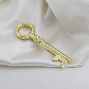 Detailopname van een gepolijste gouden sleutelhanger op zachte crème-kleurige satijnen stof