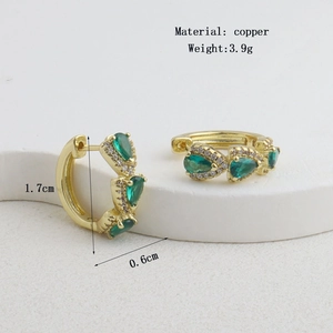 Vue macro de boucles d'oreilles créoles dorées avec pierres vertes et dimensions exactes