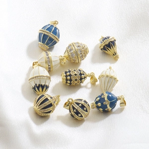 Detailed macro of golden hot air balloon charms with blue enamel and sparkling zircons