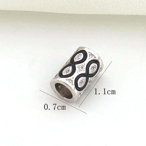 Détail macro du charm infini en or 18K avec émail noir et pierres en zircon blanc