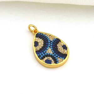 Gros plan du pendentif goutte plaqué or 18K avec zircons bleus et blancs pavés