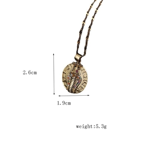 Detail of vintage gold plated Egyptian cobra pendant with multi-color rhinestones