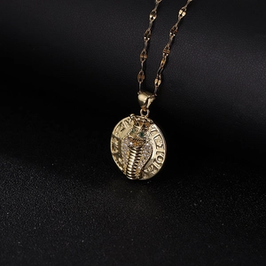 Golden cobra pendant necklace with white zircons and green gemstone eyes on flat wave chain