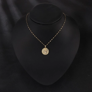 Vintage gold plated cobra pendant necklace with colorful inlay on a black display stand