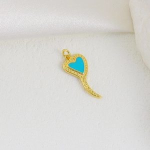 Nahaufnahme von goldenem Herz-Horn-Anhänger mit Türkis-Inlay und feiner Perlenkante
