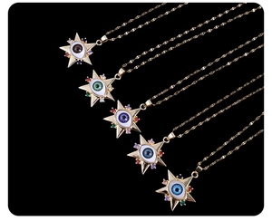 Detail von sternförmigen Evil-Eye-Anhängern in fünf Farben mit Zirkonia an Goldketten