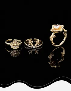 Detailed view of three gold-plated flower and elk rings with shimmering zircons