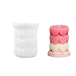 Cylindrical 3-tier heart silicone mold and DIY candle shown on a plain background