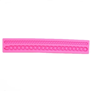 Pink silicone mold featuring two styles of textured bag chains for fondant cake decoration