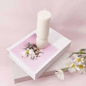 Vertical ribbed pillar candle mold on decorative books with white daisy accents