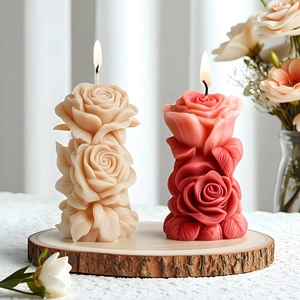 Stacked rose flower scented candles in cream and red colors on a rustic wooden base