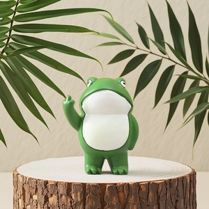 Funny green resin frog statue flipping the bird on a decorative wooden display
