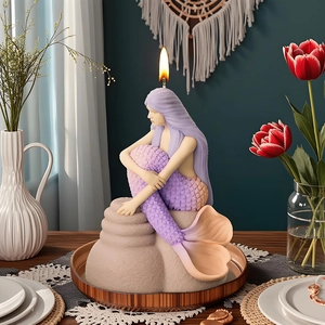 Mermaid scented candle with purple gradient design and textured sea base on a dining table