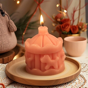 Bougie parfumée en forme de manège rose avec gravure sur un plateau en bois chaleureux