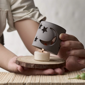 Star and moon cutout candle holder mold with wooden base and grey silicone cover