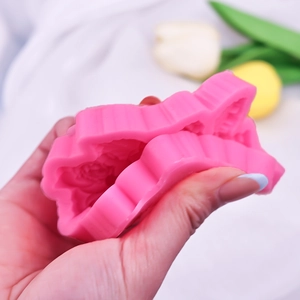 Flexible rose flower silicone mold shown being squeezed for clay or cake decorating
