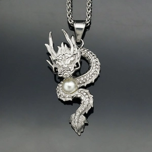 Silver dragon pendant necklace with crystal pavé and pearl detail on grey background