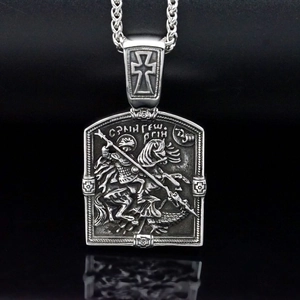 Macro detail of vintage stainless steel St. George pendant with embossed knight and dragon