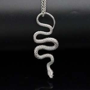 Pendentif serpent argenté avec écailles détaillées et double chaîne sur miroir noir