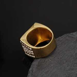 Detalle de un anillo de hip hop dorado de lujo con cristales brillantes engastados lateralmente