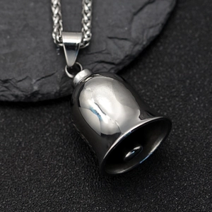 Macro detail of polished stainless steel retro biker bell pendant with braided metal chain