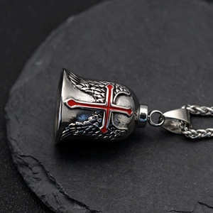 Macro detail of vintage silver biker bell with red cross and wings on stone surface