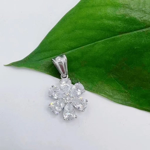 Dettaglio macro di un ciondolo a fiore in acciaio 316 con zirconi scintillanti a goccia