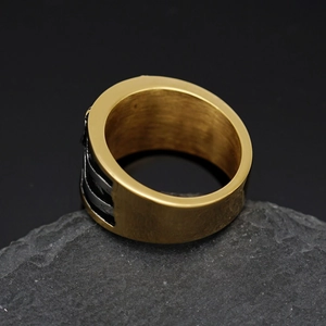 Close-up of gold stainless steel eagle ring with black side stripes on stone base