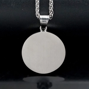 Detail of round brushed silver 316 stainless steel pendant with thick woven chain link