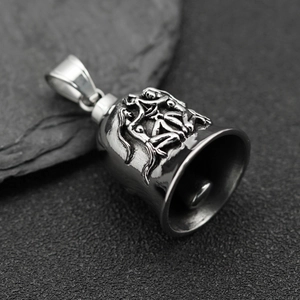 Close-up of vintage stainless steel biker bell pendant with embossed figure details