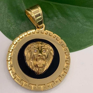 Vista macro de colgante cabeza de león en oro 18k con diseño griego en fondo negro