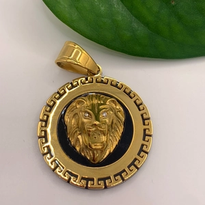 Detalle del colgante de cabeza de león dorada con borde de greca y ojos de circonita blanca