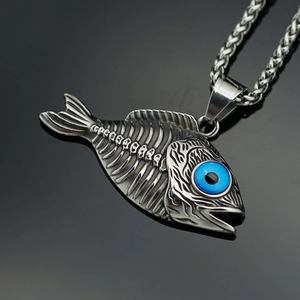 Detalle macro del colgante de espina de pescado punk con ojo azul y cadena gruesa