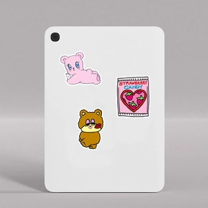 Detail of cute bear and strawberry candy stickers applied to a white laptop tablet