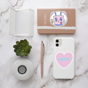 Flat lay of pink heart 'HAPPY' stickers on a white marble desk with lifestyle props
